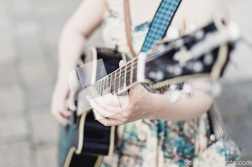 Image of Female street musician playing guitar.