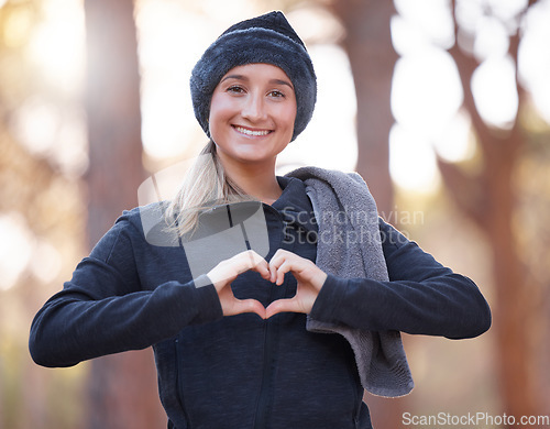 Image of Portrait, heart hands and smile of woman hiking outdoors for wellness and fitness. Valentines day, love emoji and happy female with hand gesture for romance affection, support or empathy in winter.