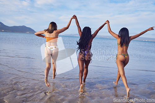 Image of Women, bikini and ocean for vacation, holding hands and summer break to relax, bonding and running. Females, friends and group touch, seaside holiday and summer trip for getaway, relax and sisterhood