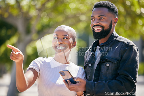 Image of Happy, phone and pointing with black couple in city for directions, travel and summer date. Smile, love and bonding with man and woman in urban town for technology, social and happiness together