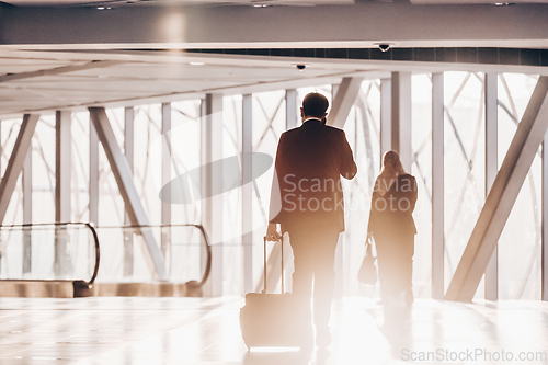 Image of Businessman at airport corridor walking to departure gates.