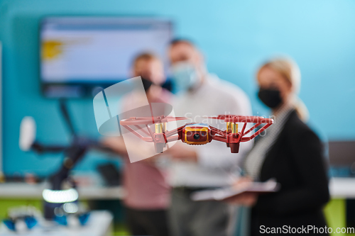 Image of A group of students working together in a laboratory, dedicated to exploring the aerodynamic capabilities of a drone