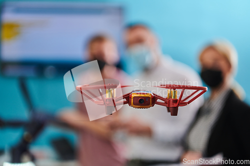 Image of A group of students working together in a laboratory, dedicated to exploring the aerodynamic capabilities of a drone