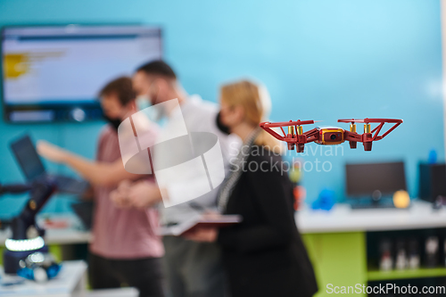 Image of A group of students working together in a laboratory, dedicated to exploring the aerodynamic capabilities of a drone