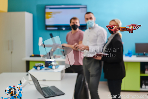 Image of A group of students working together in a laboratory, dedicated to exploring the aerodynamic capabilities of a drone