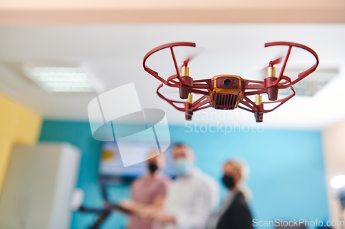 Image of A group of students working together in a laboratory, dedicated to exploring the aerodynamic capabilities of a drone