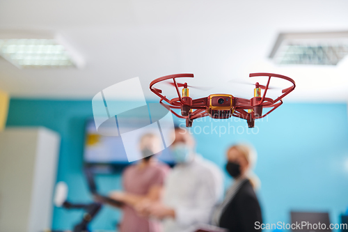 Image of A group of students working together in a laboratory, dedicated to exploring the aerodynamic capabilities of a drone