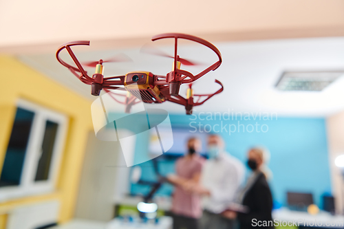 Image of A group of students working together in a laboratory, dedicated to exploring the aerodynamic capabilities of a drone