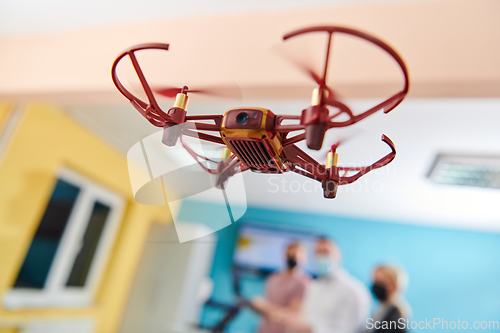 Image of A group of students working together in a laboratory, dedicated to exploring the aerodynamic capabilities of a drone