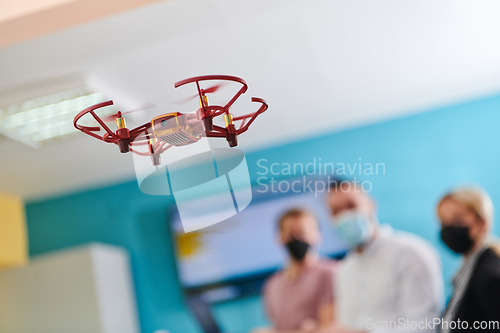 Image of A group of students working together in a laboratory, dedicated to exploring the aerodynamic capabilities of a drone