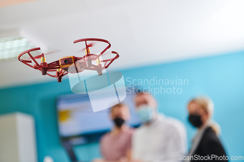 Image of A group of students working together in a laboratory, dedicated to exploring the aerodynamic capabilities of a drone