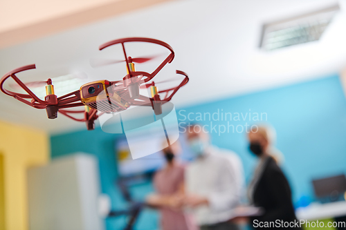 Image of A group of students working together in a laboratory, dedicated to exploring the aerodynamic capabilities of a drone