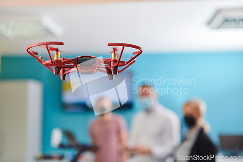 Image of A group of students working together in a laboratory, dedicated to exploring the aerodynamic capabilities of a drone