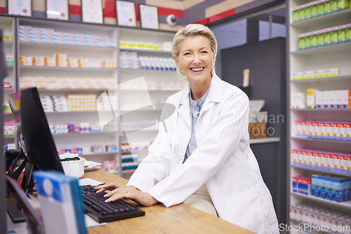 Image of Pharmacy, smile and portrait of woman pharmacist at counter in drugstore, happy customer service and advice in medicine. Prescription drugs, senior employee typing at checkout with pills and medicine