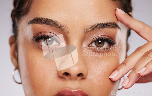 Image of Eyes, vision and beauty with contact lenses and black woman, eye care and cosmetics with closeup on studio background. Microblading, eyebrow and lashes, face and hand in portrait with manicure