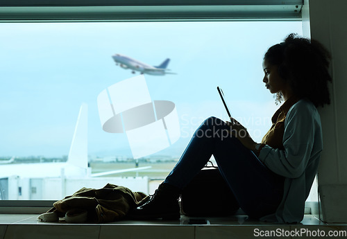 Image of Airport, travel and black woman online with tablet by window waiting for flight, departure and transport. International plane, lobby and girl with digital tech for internet, schedule and social media