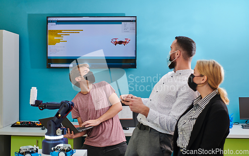 Image of A group of students working together in a laboratory, dedicated to exploring the aerodynamic capabilities of a drone