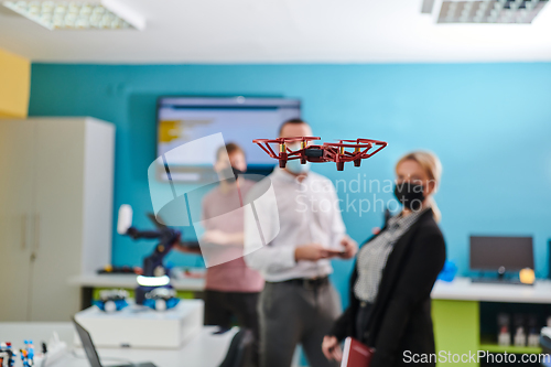 Image of A group of students working together in a laboratory, dedicated to exploring the aerodynamic capabilities of a drone