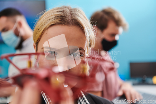 Image of A group of students working together in a laboratory, dedicated to exploring the aerodynamic capabilities of a drone