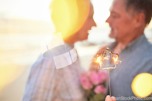 Image of Couple, sparkler and date to celebrate love, birthday and vacation or holiday at beach in summer. Senior man and woman hug outdoor with star and bokeh for sunset dating, marriage or valentines day