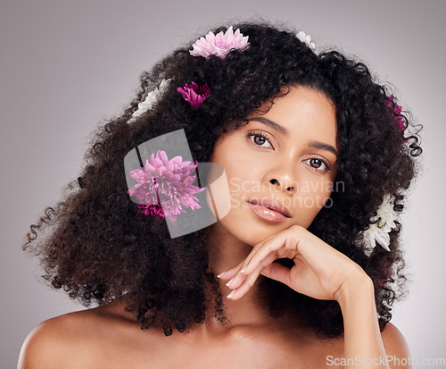 Image of Black woman, beauty and portrait with flower hair in cosmetics or skincare against a gray studio background. African American female model face with organic hairstyle or cosmetic floral art treatment