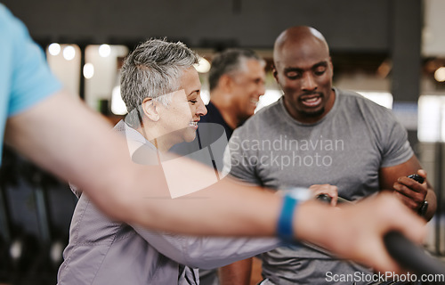 Image of Senior group, exercise bike and personal trainer for fitness, time and retirement wellness by blurred background. Elderly woman, bicycle training or diversity with black man, stopwatch and motivation