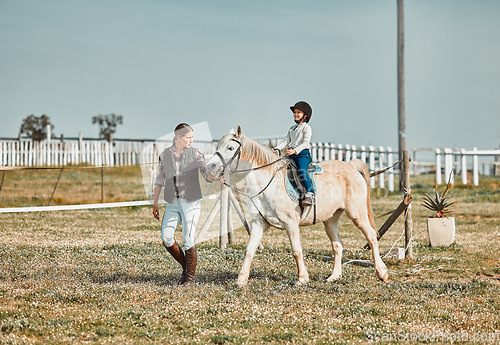 Image of .Lesson, help and woman with a child on a horse for learning, sports and hobby on a farm in Italy. Helping, support and coach teaching a girl horseback riding for a physical activity in countryside.