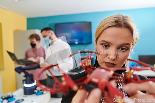 Image of A group of students working together in a laboratory, dedicated to exploring the aerodynamic capabilities of a drone