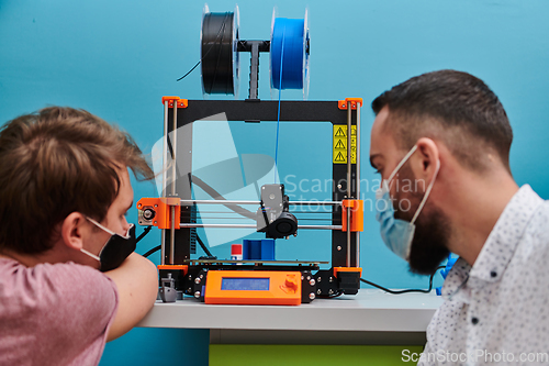 Image of A group of colleagues collaborate in a lab while testing a 3D printer, demonstrating their commitment to technological advancement and scientific research.