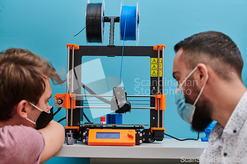 Image of A group of colleagues collaborate in a lab while testing a 3D printer, demonstrating their commitment to technological advancement and scientific research.