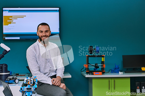 Image of A bearded man in a modern robotics laboratory, immersed in research and surrounded by advanced technology and equipment.