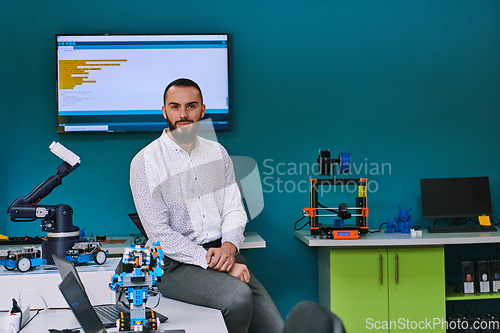 Image of A bearded man in a modern robotics laboratory, immersed in research and surrounded by advanced technology and equipment.