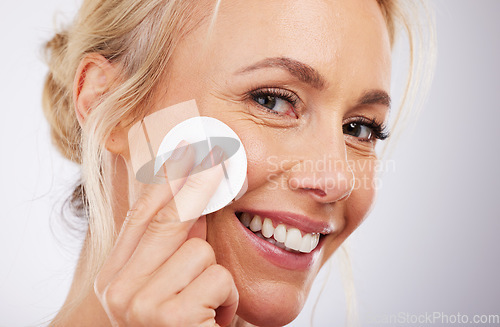 Image of Mature, facial and cotton in studio for skincare, wellness and cleaning routine on grey background. Face, skin and pad by older beauty model relax in luxury, dermatology or cosmetic grooming isolated