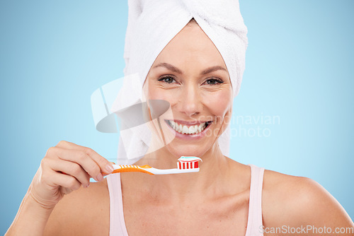 Image of Mature woman, portrait and brushing teeth isolated on blue background dental, mouth or orthodontics healthcare. Beauty model or face of happy person with toothbrush product and toothpaste in studio