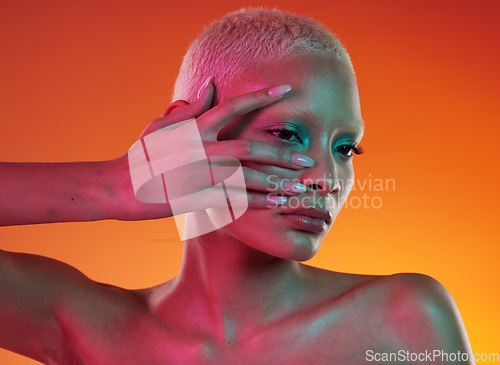 Image of Neon, cosmetics and beauty, woman with hand in face, makeup and light in creative advertising on orange background. Cyberpunk, art and model isolated in skincare and futuristic mockup space in studio