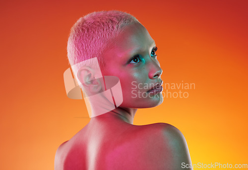 Image of Art, neon beauty and woman with face makeup and lights in creative advertising on orange background. Cyberpunk, product placement and model isolated for skincare and futuristic mockup space in studio