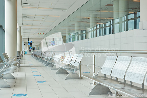 Image of Empty airport, terminal lounge and chair furniture in waiting room of departure, global travel or transportation. Airplane lobby, seat and space of commercial flight, building interior or backgrounds