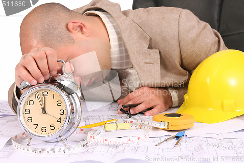 Image of A businessman sleepy with architectural plans