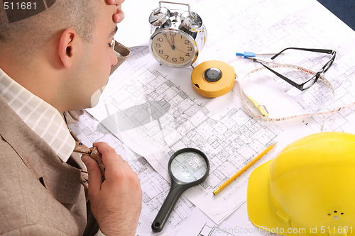 Image of A businessman sleepy with architectural plans