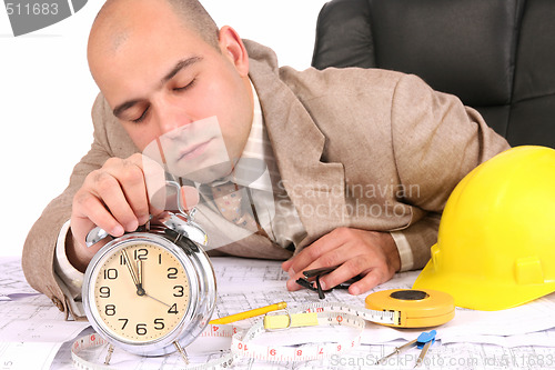 Image of A businessman sleepy with architectural plans