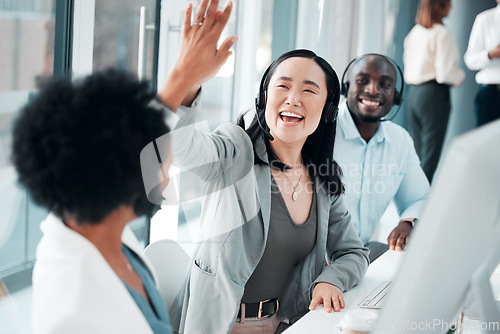 Image of Success, teamwork and high five with asian woman in call center for customer support, contact us and communication. Winner, goals and target with people in office for deal, consulting and help desk