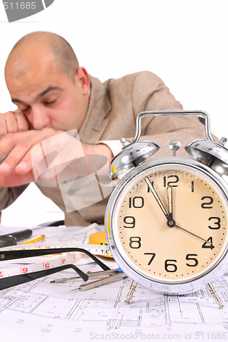 Image of A businessman sleepy with architectural plans
