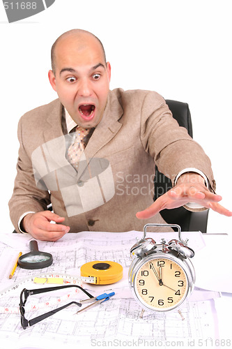 Image of businessman looking at clock alarm