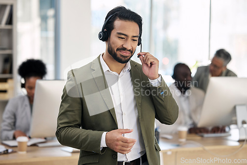 Image of Call center, smile and consulting with man in office for customer support, telemarketing and advisory. Help desk, team leader and contact us with employee listening for communication, sales and crm