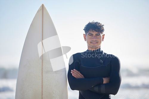 Image of Surfing, portrait and surfer man with blue sky outdoor for water sports, training and exercise. Surfboard, morning workout and sea with summer sun and young person ready for waves sport at the ocean