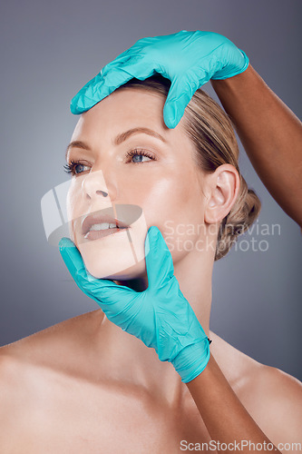 Image of Woman, studio and hands for plastic surgery, cosmetic transformation and beauty by gray background. Patient, anti aging consultation for collagen, skincare and aesthetic on face for change at clinic