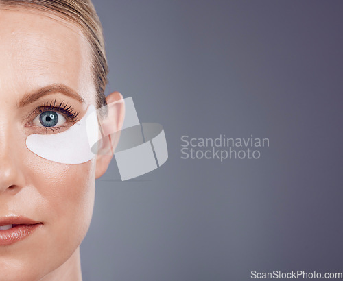 Image of Skincare mask, eyes and portrait of woman on gray background for wellness, cosmetics and facial care. Salon mockup space, dermatology and half face with pads for anti aging, makeup and beauty product