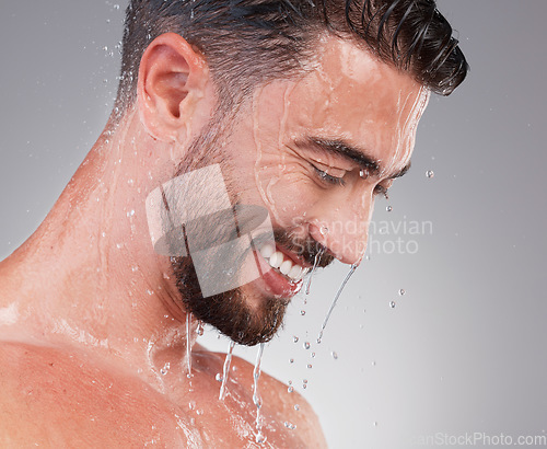 Image of Shower, grooming and smile, man isolated on grey background for skincare, health and wellness mockup in studio. Water, face and happiness, male model cleaning and washing skin and facial hair profile