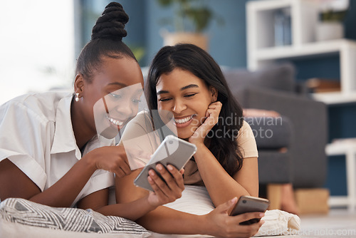 Image of Woman, friends and phone with smile for social media, online post or vlog lying on floor in living room at home. Happy women relaxing and smiling on smartphone for communication, wifi or networking