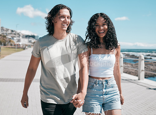 Image of Portrait, holding hands and couple at the beach for travel, fun and walking against blue sky background. Happy, love and face of woman with man on vacation, relax and bond on a trip together in Miami